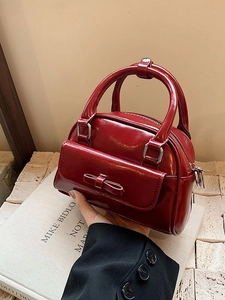 Elegant red patent leather Boston bag with bow accent and sleek top handle design