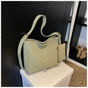 Detail view of large sage green suede tote bag with white contrast stitching and coin pouch