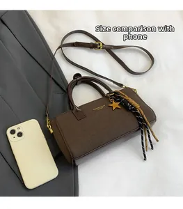 Detail view of coffee brown tote bag showing its size compared to a smartphone
