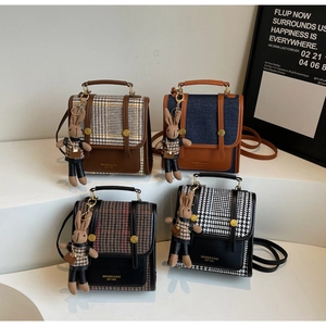 Detail of four retro flap bags with patterns like plaid, denim, and houndstooth texture
