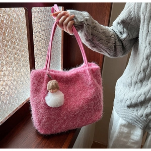 Détail de la texture en fausse fourrure rose et bandoulières en cuir du sac à main