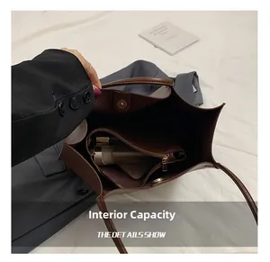 Detail view of large internal capacity and zipper compartment in brown tote bag