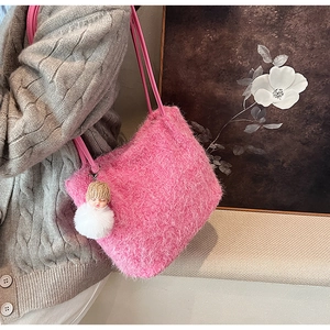 Détail d'un sac cabas en peluche rose avec un charmant pendentif et une bandoulière