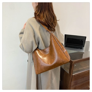 Brown large capacity PU leather tote bag with vintage finish shown on a shoulder