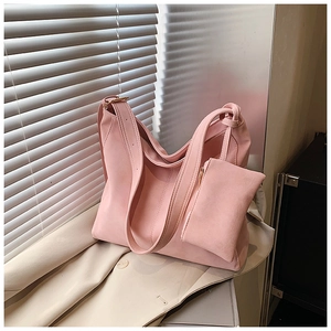 Pink matte tote bag detail with wide shoulder strap and matching small zipper pouch