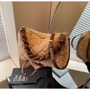 Détail du sac en peluche marron montrant la poignée en cuir tressé et la texture fourrure