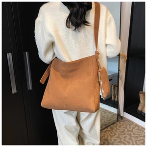 Detailed view of a brown faux leather tote bag with a matching coin purse on a shoulder strap