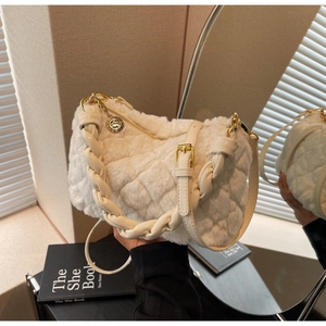 Vue détaillée du sac à main matelassé en peluche avec lanières tressées et pendentif doré