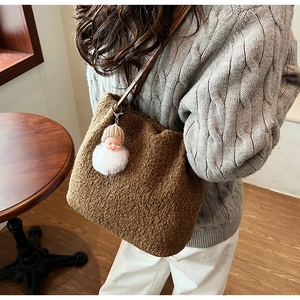 Détail du sac seau marron en polaire avec breloque en peluche et bandoulière cuir