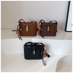 Detailed view of matte retro bucket bags in brown and black with gold metal locks