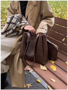 Detailed view of dark brown leather tote set with interior pouch on autumn background