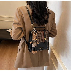Detail of retro houndstooth patchwork backpack with a cute rabbit charm on a model