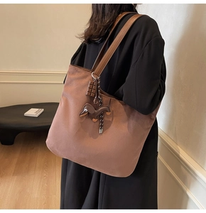 Détail du sac cabas marron foncé avec pendentif chocolat et peluche de teckel