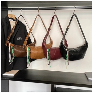 Detail view of four pleated crescent bags in coffee, caramel, wine red and black leather
