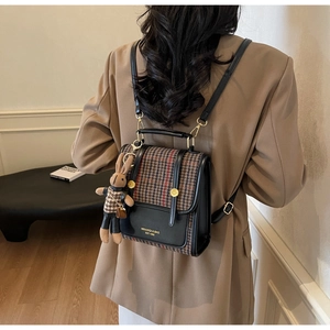 Detail of a retro contrast backpack featuring houndstooth pattern and a cute rabbit charm
