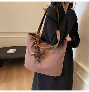 Vue détaillée du grand sac cabas marron avec texture lisse et accessoire de charme teckel