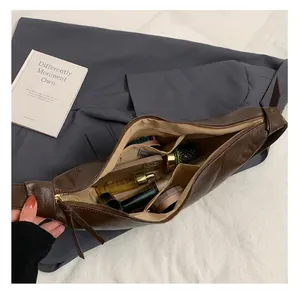 Internal view of brown leather bag showing large capacity for phone and cosmetics