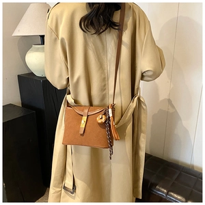 Brown frosted crossbody bag with gold lock and decorative wood pendant detail