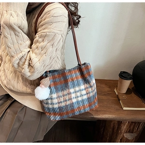 Détail du grand sac cabas en laine à carreaux avec charm pompon en décor automnal