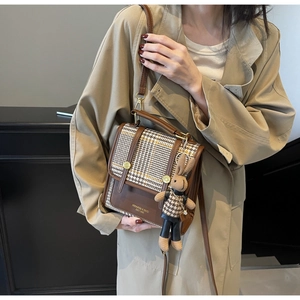 Detail of vintage plaid shoulder bag with gold hardware and a cute bunny pendant
