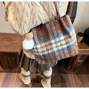 Détail du grand sac cabas en laine à carreaux vintage avec pompon et bandoulière marron