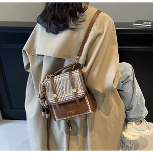 Detail of vintage plaid colorblock backpack with brand logo and cute bear charm pendant