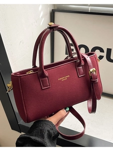 Elegant wine red leather handbag with top handles and adjustable shoulder strap
