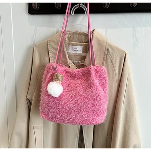 Détail du sac fourre-tout en peluche rose avec lanières et pendentif de poupée sur le côté
