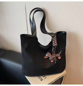 Détail du grand sac cabas en daim noir avec pendentif teckel et charms sur magazines