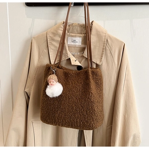 Détail d'un grand sac cabas en laine café avec texture pelucheuse et pendentif créatif