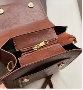 Detailed macro view of the smooth golden zipper and premium brown faux leather texture