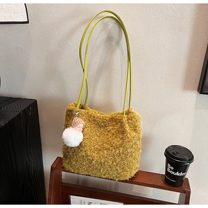 Détail du sac fourre-tout en peluche jaune avec anses vertes et charmant pendentif