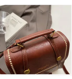 Detailed view of brown retro leather bag with gold hardware on aesthetic background