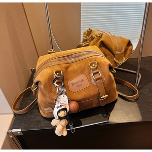 Detailed macro view of brown suede bag with Pantor Series tag and vintage hardware