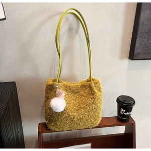 Détail du sac à épaule en fausse fourrure jaune-vert avec breloque poupée sur étagère