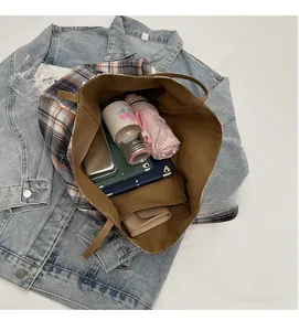 Détail de l'intérieur spacieux d'un grand sac cabas à carreaux contenant une tablette