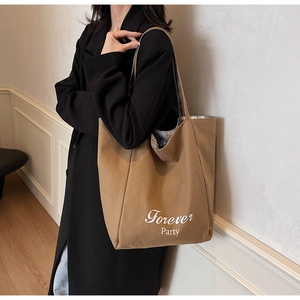 Détail du sac cabas en toile marron avec lettrage et doublure à carreaux bleus