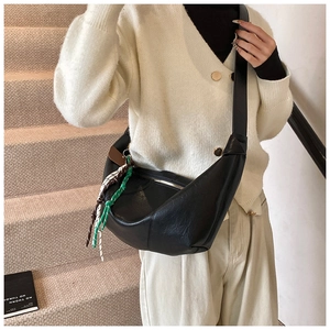 Detail of black PU leather crescent bag featuring textured surface and decorative braided rope