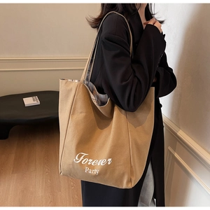 Détail du sac cabas en toile kaki avec doublure à carreaux et slogan