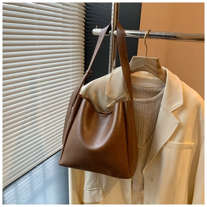 Detailed view of the adjustable shoulder strap on a brown minimalist hobo bucket bag
