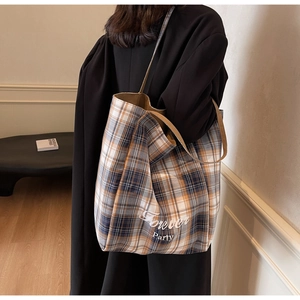 Détail du sac cabas en toile à carreaux écossais avec l'inscription Forever Party