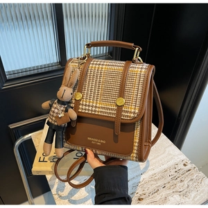 Close-up of retro plaid pattern and brand lettering on brown color-block backpack