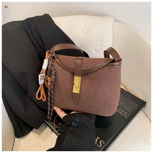 Detail view of the dark brown matte bucket bag featuring a polished leather strap and trim