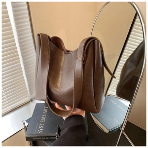 Detailed view of dark brown leather tote bag showing fine stitching and adjustable strap