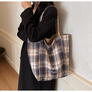 Détail du sac cabas en toile à carreaux avec imprimé Forever Party et grandes anses