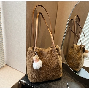 Détail du cabas en laine marron avec poignées en cuir et breloque en peluche douce