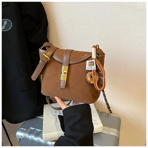 Close-up of brown frosted crossbody bag featuring a gold metal twist lock and donut charm