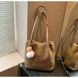 Détail du cabas en peluche marron avec bandoulière en cuir et charm poupée mignon