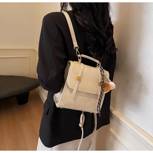 Detail of cream PU leather backpack with vintage texture and stylish charms
