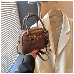 Détails d'un sac à main Boston marron avec ferrures dorées et breloque à gland